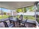Enclosed patio featuring a table and chairs with views of the green backyard at 612 Ralph St, Auburndale, FL 33823