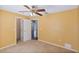 A yellow bedroom features a ceiling fan, neutral carpet, and views to other rooms at 6560 Horizon Point Dr, Lakeland, FL 33813