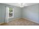 A well-lit bedroom features a ceiling fan, window, and neutral carpet at 6560 Horizon Point Dr, Lakeland, FL 33813