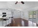Living room with hardwood floors, ceiling fan, vaulted ceilings, breakfast bar, and views of the kitchen and lanai at 6560 Horizon Point Dr, Lakeland, FL 33813