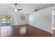 Vaulted ceiling living room with hardwood floors, ceiling fan, slider doors to the lanai, and a view of the bathroom at 6560 Horizon Point Dr, Lakeland, FL 33813