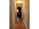 Hallway featuring wood floors leading to a brightly lit room with sofa and desk at 670 Avenue N Se, Winter Haven, FL 33880