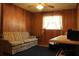 Living room featuring wood paneled walls with striped sofa and wooden table at 670 Avenue N Se, Winter Haven, FL 33880