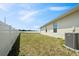 Spacious, fenced backyard with healthy grass and an air conditioning unit at 730 Colville Pl, Kissimmee, FL 34759