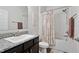Clean bathroom offers a granite-topped vanity, decorative shower curtain, and fresh white tile at 730 Colville Pl, Kissimmee, FL 34759