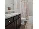 Bathroom featuring granite-topped vanity, decorative shower curtain, and fresh white tile at 730 Colville Pl, Kissimmee, FL 34759