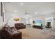 Spacious living room featuring plush leather seating, a ceiling fan, and large windows for ample natural light at 730 Colville Pl, Kissimmee, FL 34759