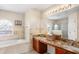 Bathroom featuring dual sinks, vanity, and large soaking tub with natural light at 780 Gila Dr, Kissimmee, FL 34759