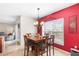 Bright dining room with bold red wall, large window, and modern chandelier at 780 Gila Dr, Kissimmee, FL 34759
