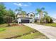 Exterior view of two-story home, driveway, with lawn and tropical palms at 780 Gila Dr, Kissimmee, FL 34759