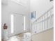 Bright foyer with tiled floors and a staircase with white railings at 780 Gila Dr, Kissimmee, FL 34759