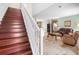 Open-concept living room featuring dark wood stairs, tiled floors, and elegant furnishings at 780 Gila Dr, Kissimmee, FL 34759