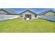 Backyard with green lawn, patio seating area, and enclosed with white vinyl fencing for privacy at 8243 Campbell Crossing Cir, Lakeland, FL 33810