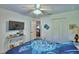 Bedroom with a turtle-themed bedspread, TV, ceiling fan, and double door closet at 8243 Campbell Crossing Cir, Lakeland, FL 33810