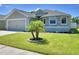 Charming single-story home featuring a stone facade, two-car garage, and a well-manicured front lawn with palm tree accent at 8243 Campbell Crossing Cir, Lakeland, FL 33810