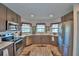 Kitchen with stainless steel appliances, wood cabinets, light countertops, and bay windows over the sink at 8243 Campbell Crossing Cir, Lakeland, FL 33810