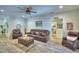 This bright living room has plenty of comfortable seating, wood-look floors, and stylish decor at 8243 Campbell Crossing Cir, Lakeland, FL 33810