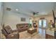 Spacious living room with leather furniture, wood-look floors, and double doors to the backyard at 8243 Campbell Crossing Cir, Lakeland, FL 33810