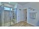 This bathroom has a glass enclosed tiled walk-in shower, wood-look tile flooring, and a linen closet at 825 Grazie Loop, Davenport, FL 33837