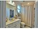 Bright bathroom featuring a shower, granite counters, a large mirror, and ample storage at 825 Grazie Loop, Davenport, FL 33837