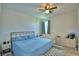 Comfortable bedroom with a large window that provides natural light, a ceiling fan, and neutral decor at 825 Grazie Loop, Davenport, FL 33837