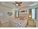 This bedroom features a tray ceiling, ceiling fan, and a queen size bed with an ornate headboard at 825 Grazie Loop, Davenport, FL 33837