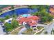 Scenic aerial view of community center with pool, lake, parking, and lush landscaping at 825 Grazie Loop, Davenport, FL 33837