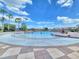View of community pool with children playing in the water under a bright blue sky at 825 Grazie Loop, Davenport, FL 33837