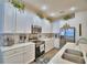 Close-up of a bright eat-in kitchen featuring white cabinets, stainless appliances, and granite countertops at 825 Grazie Loop, Davenport, FL 33837