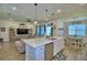 Bright eat-in kitchen with an island and stainless steel dishwasher overlooking the living room and dining area at 825 Grazie Loop, Davenport, FL 33837
