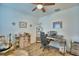 This office space features a wood-look tile floor, ceiling fan, and large desk area at 825 Grazie Loop, Davenport, FL 33837