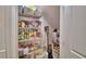 Walk-in pantry featuring wire shelving stocked with canned goods, snacks, and paper products at 825 Grazie Loop, Davenport, FL 33837