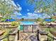 Resort-style community pool and recreation area with lush landscaping, lounge chairs, and shade umbrellas at 825 Grazie Loop, Davenport, FL 33837