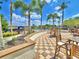 View of the pool area with lounge chairs, tables, umbrellas, and lush landscaping at 825 Grazie Loop, Davenport, FL 33837
