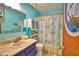 Cozy bathroom with blue walls, a vessel sink, and nautical themed shower curtain at 842 Cinnamon Dr, Winter Haven, FL 33880