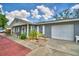 Inviting single-story home with attached garage, beautifully landscaped front yard, and brick-paved walkway at 842 Cinnamon Dr, Winter Haven, FL 33880