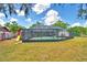The backyard features a screened-in pool, slide, and lush green lawn, perfect for outdoor entertaining at 842 Cinnamon Dr, Winter Haven, FL 33880