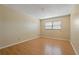 Empty bedroom with wood flooring and a window with blinds at 100 El Camino Dr # 309, Winter Haven, FL 33884