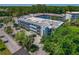 A view showcases the building's exterior and design, surrounded by lush greenery and parking area at 100 El Camino Dr # 309, Winter Haven, FL 33884