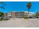 Granada Condo complex featuring three stories with parking, landscaping, and community signage on a clear sky day at 100 El Camino Dr # 309, Winter Haven, FL 33884