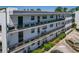 Exterior view of condo building featuring balconies, black metal railings, and surrounding landscaping at 100 El Camino Dr # 309, Winter Haven, FL 33884