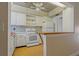 Kitchen featuring white cabinets, appliances, butcher block breakfast bar, and unique ceiling at 100 El Camino Dr # 309, Winter Haven, FL 33884