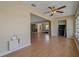 Open-concept living area with wood-look floors, ceiling fan, and seamless flow to bedroom at 100 El Camino Dr # 309, Winter Haven, FL 33884