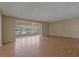 Spacious living room featuring wood floors and large windows offering plenty of natural light and a view of the outdoors at 100 El Camino Dr # 309, Winter Haven, FL 33884