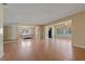 Open-concept living room with wood flooring and adjacent bedroom featuring large windows and a mirror sliding door at 100 El Camino Dr # 309, Winter Haven, FL 33884