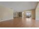 Open-concept living room with wood flooring, neutral walls, large mirror closet doors, and lots of natural light at 100 El Camino Dr # 309, Winter Haven, FL 33884