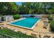 A clear swimming pool is featured in a fenced-in area, surrounded by lounge chairs and green foliage at 100 El Camino Dr # 309, Winter Haven, FL 33884
