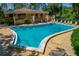 A clear swimming pool is featured in a fenced-in area, surrounded by lounge chairs and greenery at 100 El Camino Dr # 309, Winter Haven, FL 33884