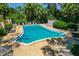 Inviting outdoor pool area with lounge chairs, surrounded by lush tropical landscaping and serene natural beauty at 100 El Camino Dr # 309, Winter Haven, FL 33884