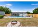 Spacious backyard with a swimming pool, fire pit, and privacy fencing at 100 Ellen Ct, Winter Haven, FL 33884